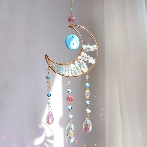 Crystal suncatcher with moon-shaped stones and evil eye beads for rainbow light effects