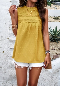 Detailed view of yellow sleeveless top featuring dot texture and lace trim on a model