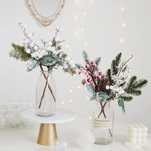 Christmas pine needle bouquet with red berries, candy canes and snow effect in a glass vase