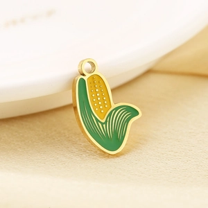 Macro detail of a golden enamel corn pendant with yellow kernels and green leaves