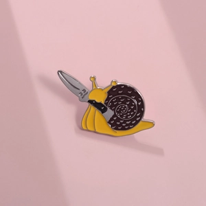 Close-up of a creative cartoon snail enamel pin with a knife on a pink background