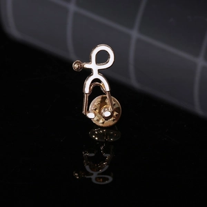 Macro shot of a medical stethoscope brooch with gold metal and white enamel inlay