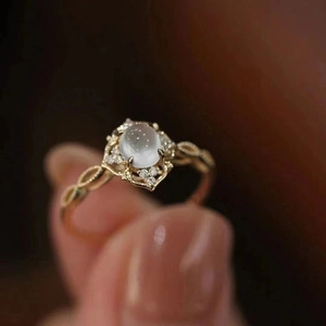 Macro-opname van vintage gouden ring met ronde maansteen en ingelegde zirkonen