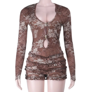 Detail of brown floral lace romper with pearl buttons, cut-outs, and ruffled hem edges