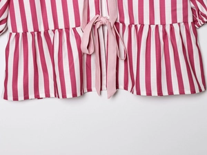 Close-up of pink and white striped fabric with drawstring ties and ruffle details
