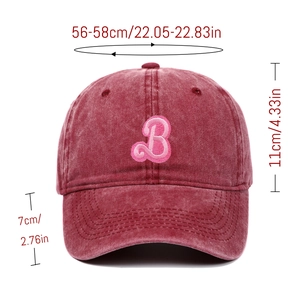 Macro detail of the letter B embroidery and washed fabric texture on the pink baseball cap