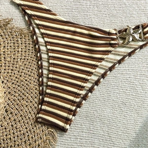 Macro shot of striped bikini bottom with ribbed fabric and gold starfish ornament