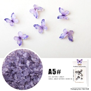 Detailed macro view of purple 3D butterfly nail charms with bulk packaging view