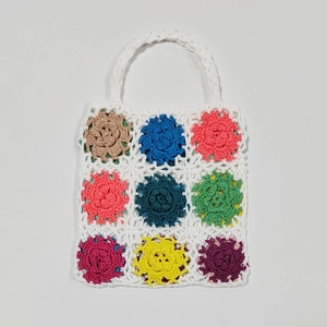 Close-up of handmade crochet tote bag featuring multi-colored floral granny square patterns