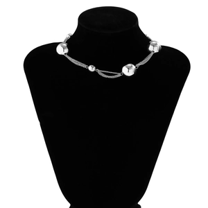 Detail of silver layered choker necklace with large beads on black velvet mannequin
