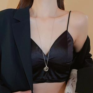 Close-up of minimalist interlocking ring pendant necklace on model with black outfit