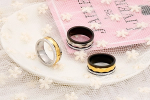 Detail of faceted stainless steel rings with crystal inlay on white lace background
