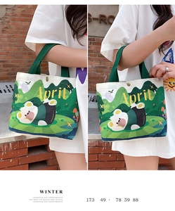 Detail view of the green canvas tote bag featuring cute cartoon bear and forest illustrations
