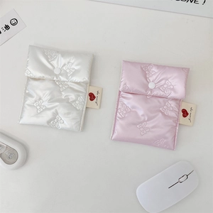 Close-up of quilted satin sanitary storage pouches with bow details and button closure