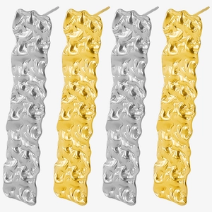 Detailed macro of gold and silver stainless steel earrings with organic lava texture