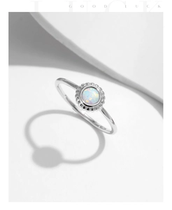 Macro detail of S925 sterling silver ring featuring a round opal with retro halo setting