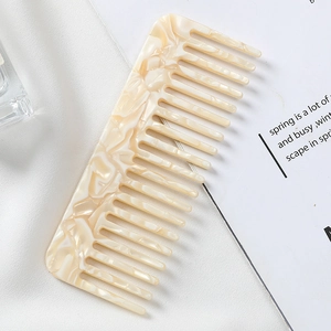 Detail of beige marble pattern acetate hair comb with wide teeth for anti-static styling