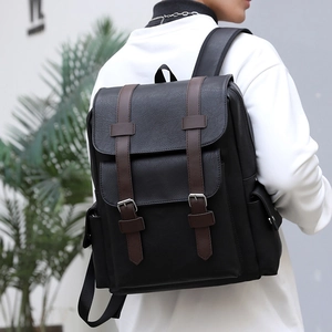 Large capacity black PU leather backpack with brown straps shown on a model
