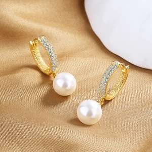 Detail of 18K gold pearl drop earrings with sparkling micro-pave cubic zirconia