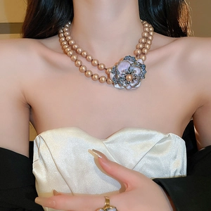 Detail of double-layer champagne pearl necklace with blue rhinestone flower pendant