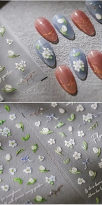 Detailed view of 5D embossed nail stickers with white tulips and blue bows