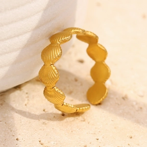 Vue macro détaillée de la bague ouverte en acier doré avec motif de coquillages
