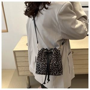 Détail du sac seau à motif léopard avec cordon de serrage et bandoulière noire réglable