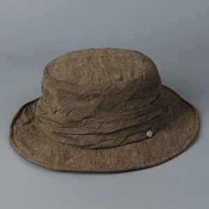 Detailed view of a vintage linen bucket hat with textured fabric and metal logo tag.