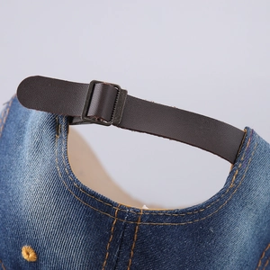 Arrière d'une casquette en denim avec sangle réglable en cuir marron et boucle métal