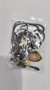 Detail of ethnic feather pendant necklace with turquoise stone and beads in packaging