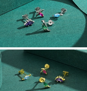 Macro view of dinosaur stud earrings in S925 silver with colorful pear-cut crystals