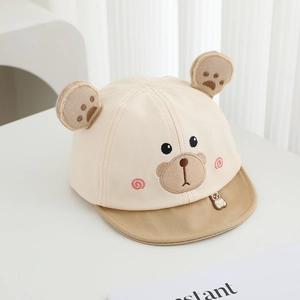 Dettaglio del cappellino beige per neonati con orecchie da orso e ricamo frontale
