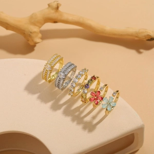 Dettaglio di anelli a fiore placcati oro 14K con zirconi e pietre preziose colorate