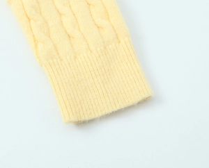 Macro view of yellow knit cardigan cuff with textured cable knit and ribbed detailing