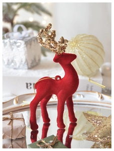 Macro view of red flocked Christmas deer with gold glitter antlers and festive accents