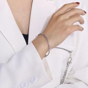 Polished stainless steel cuff bracelet with spherical beads worn by a female model