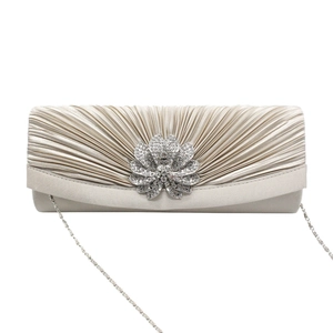 Detailed shot of champagne satin pleated evening bag with floral rhinestone buckle