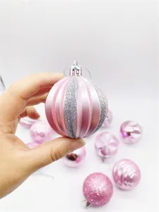 Close-up of a pink Christmas ornament with silver glitter stripes and top silver ring