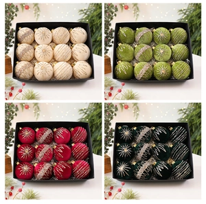 Detail of velvet Christmas balls in cream, green, and burgundy with golden glitter