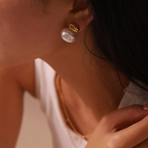 Close-up of model wearing 16K gold plated stainless steel earring with large white pearl