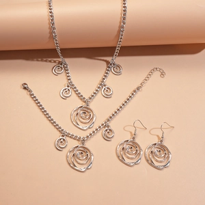 Macro shot of silver jewelry set including rose pendant necklace bracelet and earrings