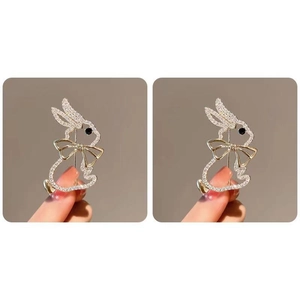 Close-up of a cute gold rabbit brooch featuring sparkling rhinestones and a metal bow