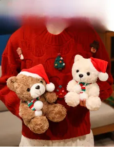 Close-up of plush Teddy bear doll with festive red Christmas hat and striped scarf detail