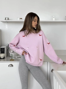 Detailed close-up of pink knit sweater featuring red and white dachshund embroidery