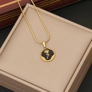 Detailed macro of vintage gold rose pendant with black enamel on a snake chain