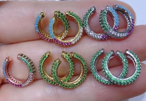 Detailed view of C-shaped ear cuffs featuring multi-color crystals and micro-pave setting