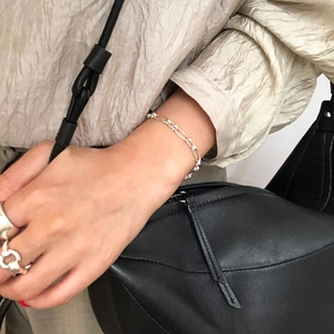 Minimalist 925 sterling silver O-chain bracelet and link rings worn with a stylish outfit