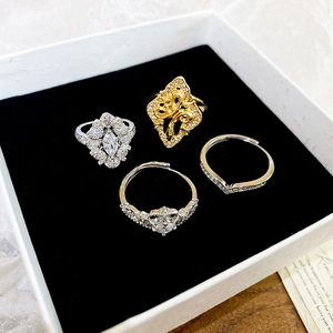 Detailed set of four vintage rings with floral and zircon accents on black velvet