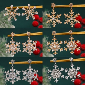 Elegant Christmas snowflake stud earrings with pearls and rhinestones on festive display