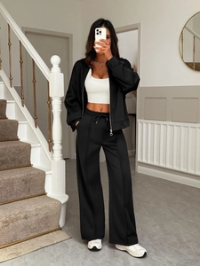 Full view of a comfortable black two-piece casual lounge set with zipper jacket and wide pants